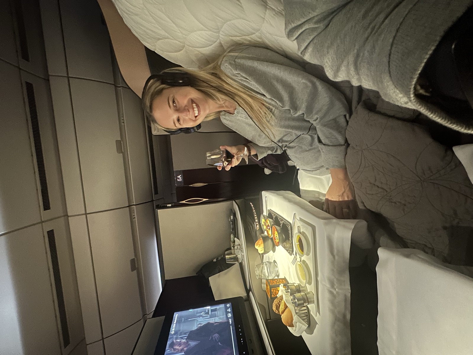 Christie enjoying a meal and a glass of wine in a business-class seat